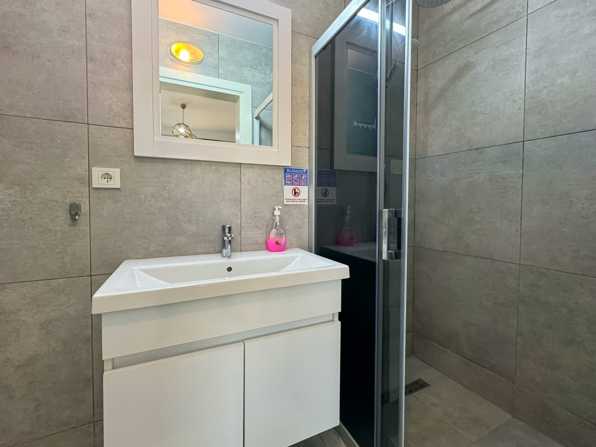 Main bathroom with walk-in shower, vanity and framed mirror