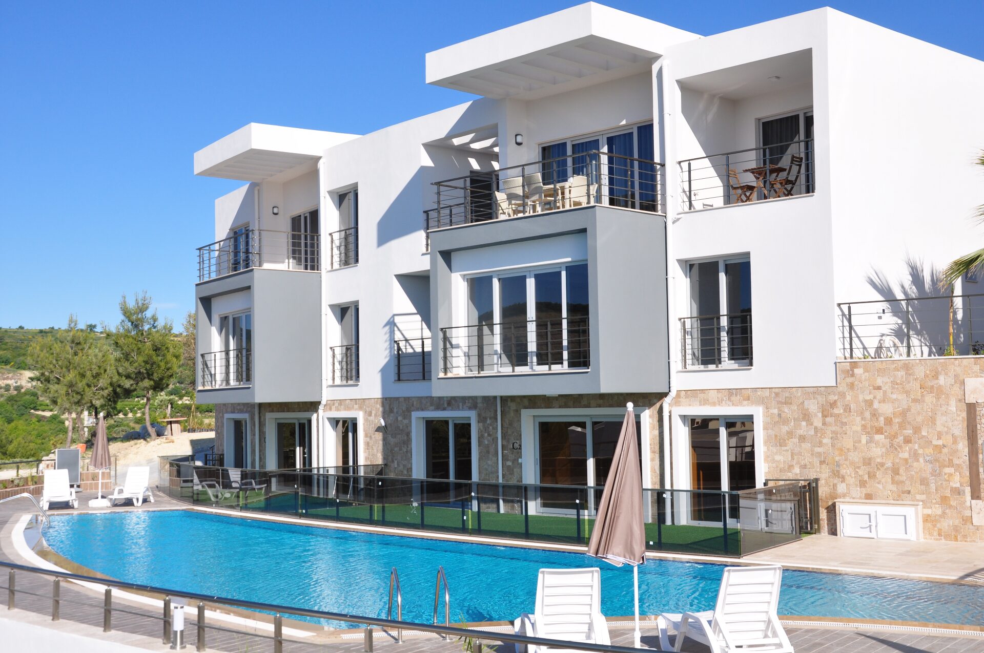 Side view of the residences and pool with stone-clad facades