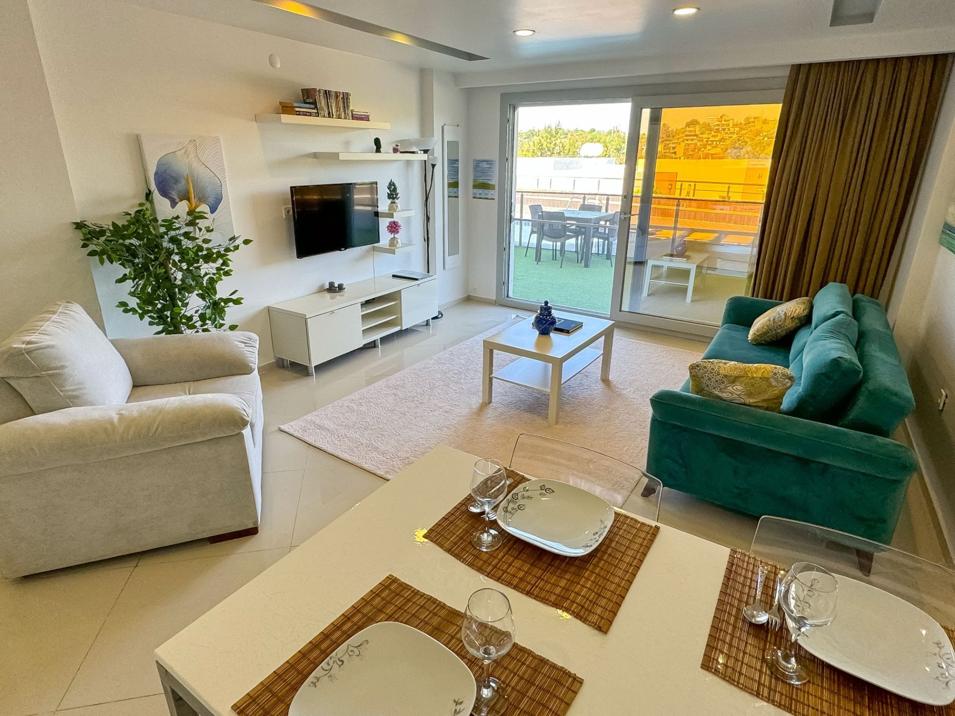 Pool-side apartment living room with dining table and terrace access