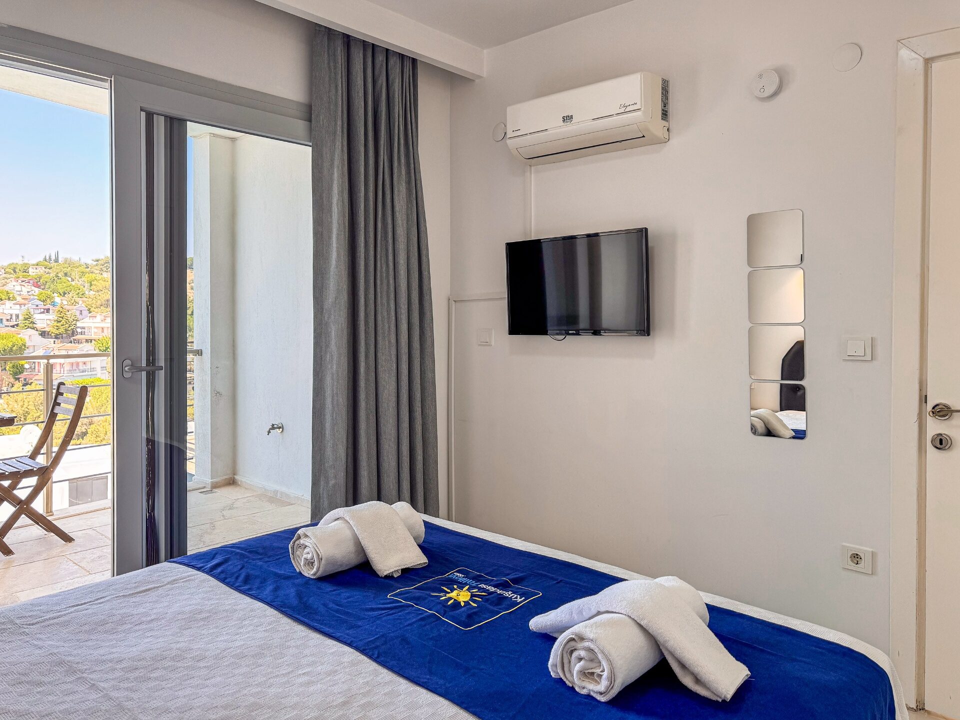 Second bedroom with double bed, wall-mounted TV, air conditioning and private balcony