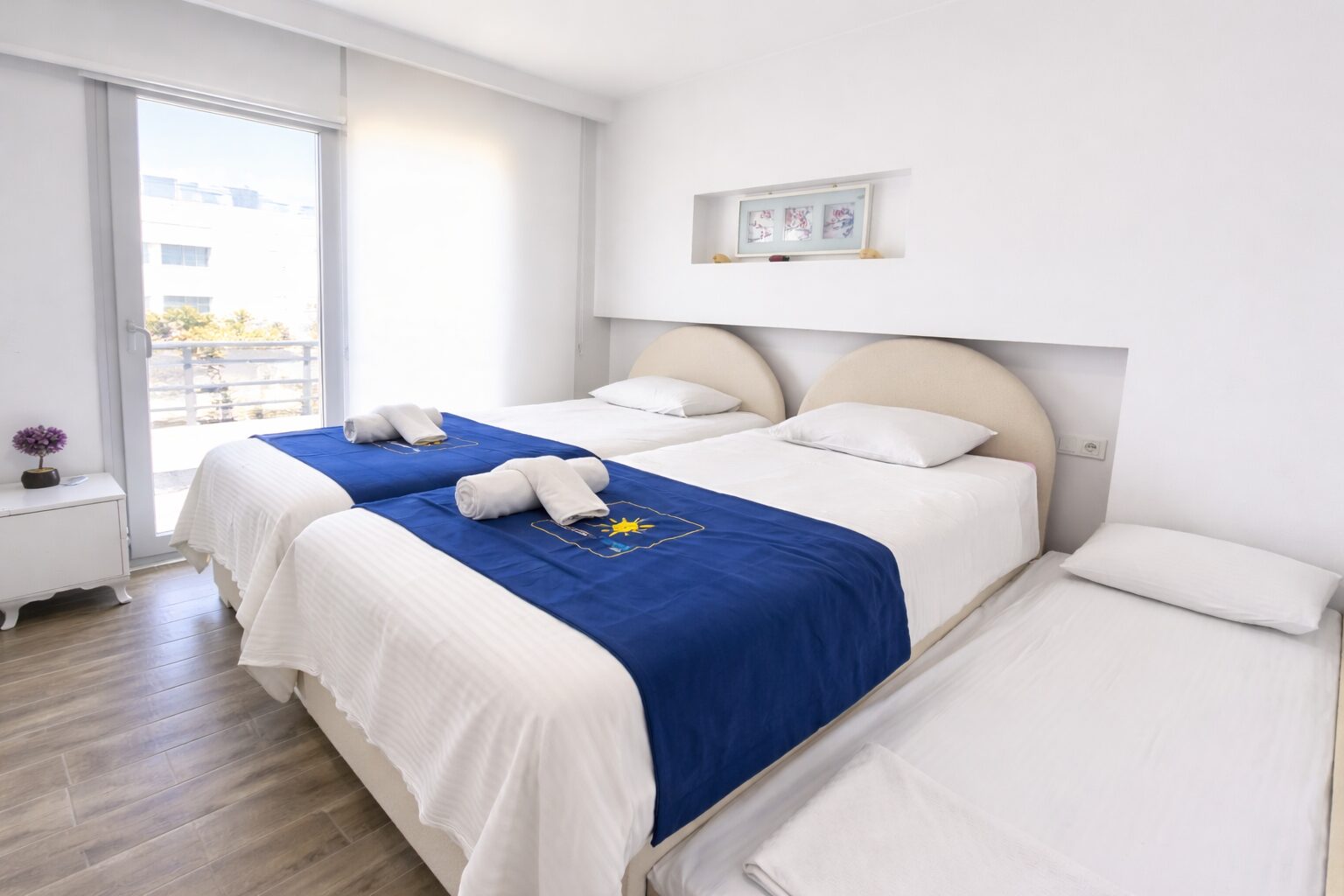 Twin bedroom with two single beds, trundle and balcony doors